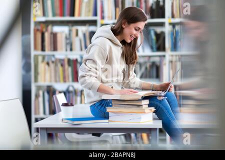 Young female student studying in the library Stock Photo