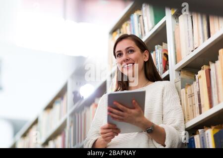Young female student studying in the library Stock Photo