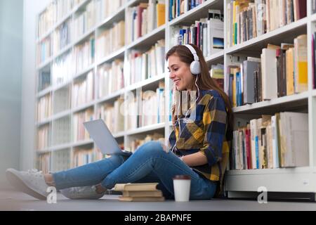 Young female student studying in the library Stock Photo
