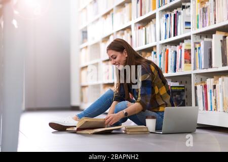 Young female student studying in the library Stock Photo