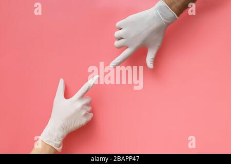Two hands covered with rubber gloves reaching towards each other Stock Photo