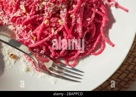 Spaghetti pasta with pink beetroot sause in a white bowl Stock Photo