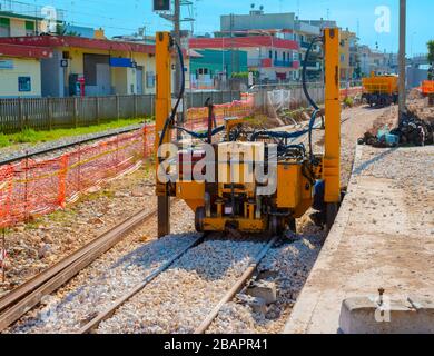 Construction of a new railway line at a city station. Hydraulic lifting machines make it possible to lift, move laterally and lay points of various di Stock Photo