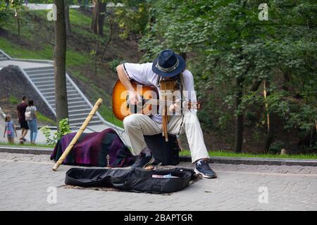 Kiev, Ukraine - July 28, 2019: Street musician plays guitar in the city park Stock Photo