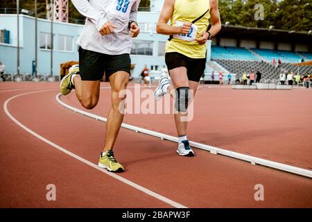 two man athletes run on track of stadium marathon race Stock Photo