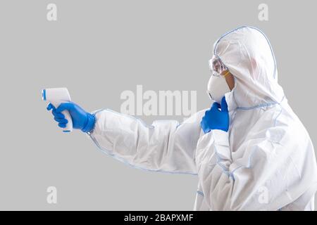 Man in protective suit with thermometer measure temperature Stock Photo