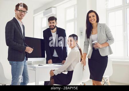Businesspeople team in a meeting discussing a startup project at a table in an office with windows. Stock Photo