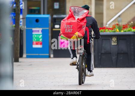 Glasgow, UK. 27 March 2020.   Pictured: Just Eat cyclist seen delivering  The Coronavirus Pandemic has forced the UK Government to order a shut down of all the UK major cities and make people stay at home, which has left the motorways and all other roads free of the usual nose to tail traffic which would otherwise be there. Credit: Colin Fisher/Alamy Live News. Stock Photo