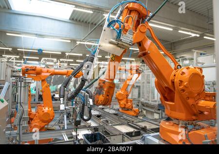 orange robot arms on the production line. controlled by a computer with artificial intelligence Stock Photo