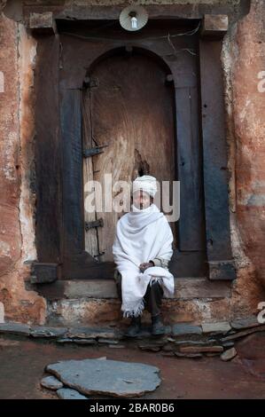 Church of the Rock Abreha Atsbeha, Monastery Abreha wa Atsbeha, Ethiopia. A cleric at the door of the church of Abreha Atsbeha, semi excavated in the Stock Photo