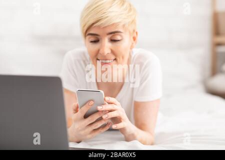 Attractive lady chatting in social networks while working on laptop Stock Photo