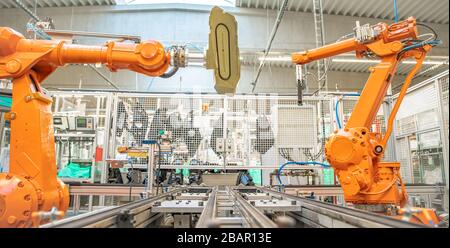 orange robot arms on the production line. controlled by a computer with artificial intelligence Stock Photo