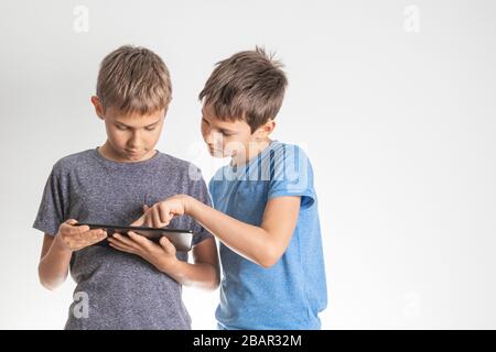 Children using digital tablet pc computer. Technology, online learning, education, distance learning, game apps for kids Stock Photo