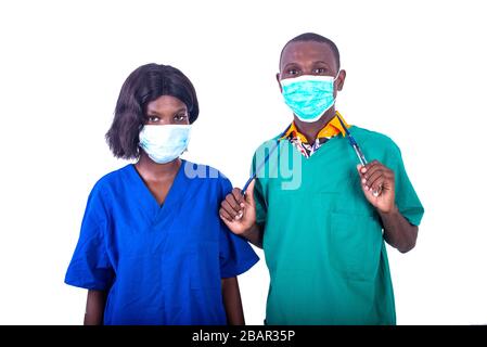 two young doctors in uniform wearing a medical mask at the hospital looking at the camera. Stock Photo