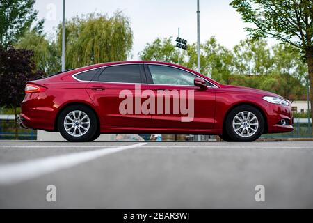 Ford Mondeo MK5 Titanium trim, in Ruby red coloud, sedan, photosession in an empty parking lot. Isolated car, nice photos Stock Photo