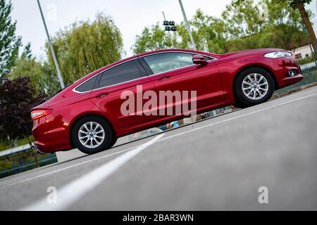 Ford Mondeo MK5 Titanium trim, in Ruby red coloud, sedan, photosession in an empty parking lot. Isolated car, nice photos Stock Photo