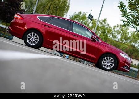 Ford Mondeo MK5 Titanium trim, in Ruby red coloud, sedan, photosession in an empty parking lot. Isolated car, nice photos Stock Photo