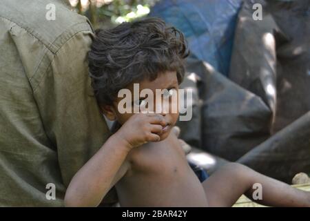 a tribal child sitting with his father - Kerala,Lahai ,Pathanamthitta Stock Photo