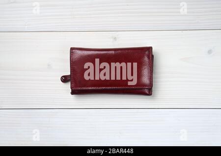 Brown leather purse on a white wooden background Stock Photo