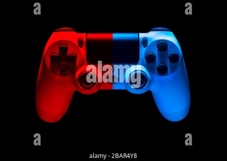 White video game joystick gamepad in blue and red neon lights isolated on a black background with clipping path Stock Photo