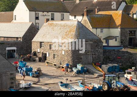 The old winch house, used for winching fishing boats up the beach, and the Inn behind, in the quaint fishing village of Cadgwith, Cornwall, England Stock Photo