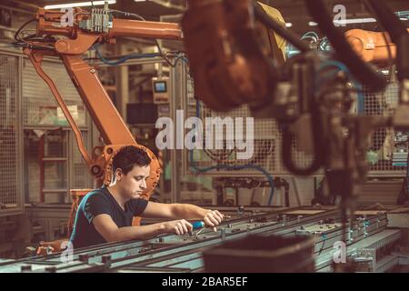 setup and service of the production line with robotic arms in the factory Stock Photo