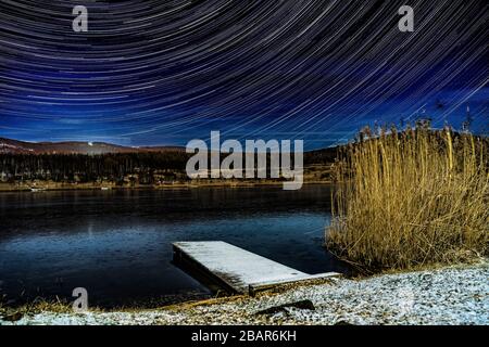 Star trails above the lake in northern Bohemia Stock Photo
