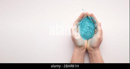 Blue powder paint in hands for Holi Stock Photo