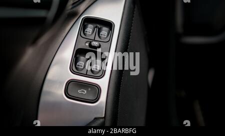 Front and back electric windows buttons-lower or close car windows. Avantgarde leather interior with sport trim-aluminium ornaments around Stock Photo