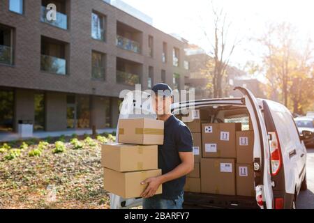 Smiling delivery man with his van Stock Photo