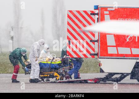 29 March 2020, North Rhine-Westphalia, Mülheim an der Ruhr: A patient is transported at the airport from a military helicopter to an ambulance. A total of two patients are to be transported from Metz in France to the University Hospital in Essen. Photo: Marcel Kusch/dpa Stock Photo