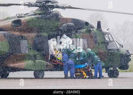 29 March 2020, North Rhine-Westphalia, Mülheim an der Ruhr: A patient is transported at the airport from a military helicopter to an ambulance. A total of two patients are to be transported from Metz in France to the University Hospital in Essen. Photo: Marcel Kusch/dpa Stock Photo