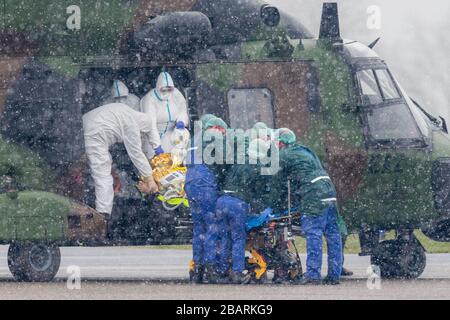 29 March 2020, North Rhine-Westphalia, Mülheim an der Ruhr: A patient is transported at the airport from a military helicopter to an ambulance. A total of two patients are to be transported from Metz in France to the University Hospital in Essen. Photo: Marcel Kusch/dpa Stock Photo