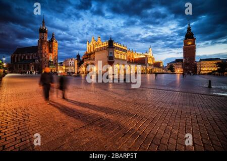 Evening at Main Market Square in Old Town of Krakow city in Poland, St Mary Basilica, Cloth Hall and Town Hall Tower historic landmarks