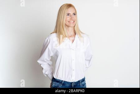 Indoor portrait of beautiful blonde mature lady smiling Stock Photo