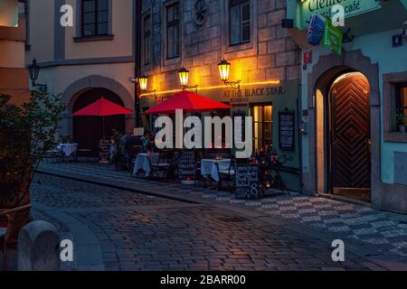 Small outdoor restaurant on evening cobblestone street in Old Town of Prague. Stock Photo