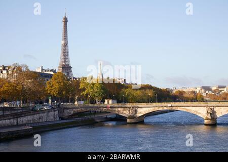 Eiffel tower, bridge and Seine river view with autumn trees in a sunny day in Paris, France Stock Photo