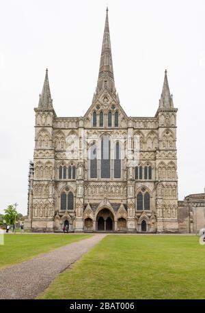 Front view of Salsbury Cathedral: The front facade of Salisbury Cathedral and the entrance walkway. A fine green park surrounds the great cathedral at Salisbury. Stock Photo