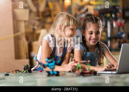 Small girls cooperating while making a robot Stock Photo