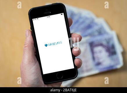 A woman using the Barclays Bank app on a mobile phone. (Editorial Use Only) Stock Photo