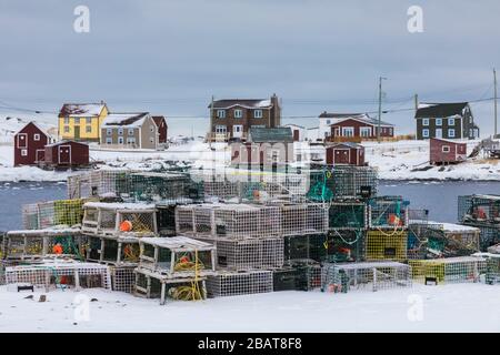 Lobster pots, stages, and houses along Tilting Harbour in the historic fishing village of Tilting, on Fogo Island in Newfoundland, Canada Stock Photo