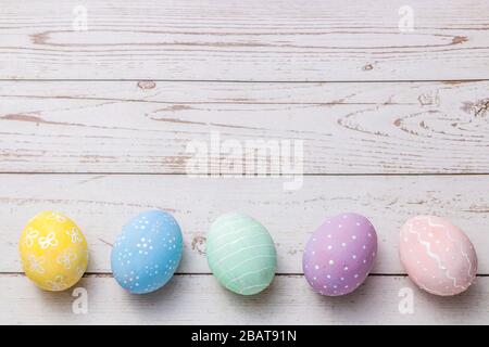 easter background with hand painted pastel colors eggs on light colored wooden table Stock Photo