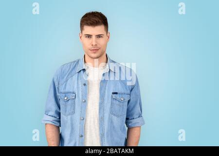 Freestyle. Young man in jean jacket standing isolated on gray siling confident Stock Photo