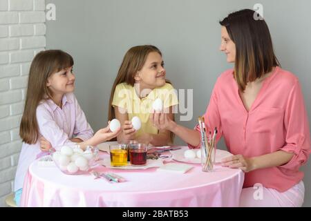 Mom and two daughters are going to dye eggs for Easter Stock Photo
