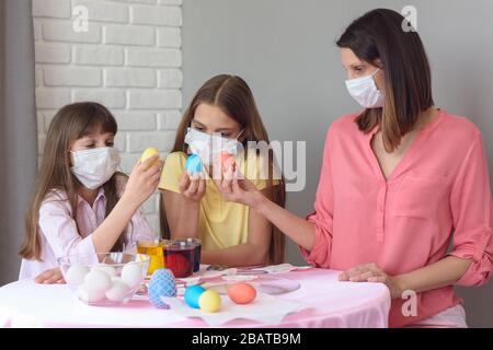Mom and two quarantined daughters painted eggs for Easter Stock Photo