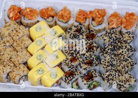 Sushi and rolls home delivery. Krpny plan. Sesame, salmon, cheese. Stock Photo