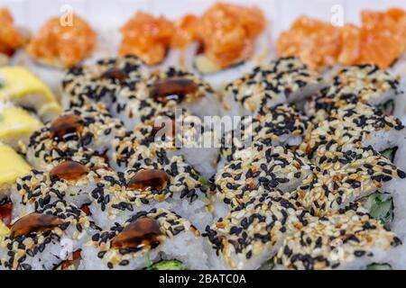 Sushi and rolls home delivery. Krpny plan. Sesame, salmon, cheese. Stock Photo