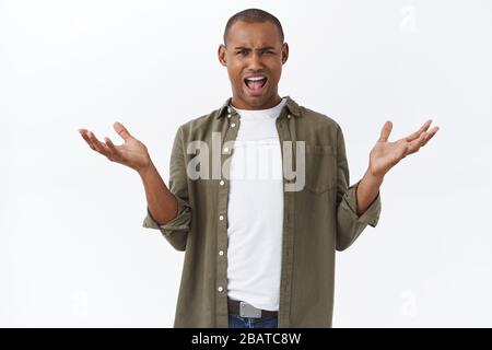 Whats your problem. Portrait of frustrated and annoyed african-american man, spread hands sideways complaining, having argument, look confused, cant Stock Photo