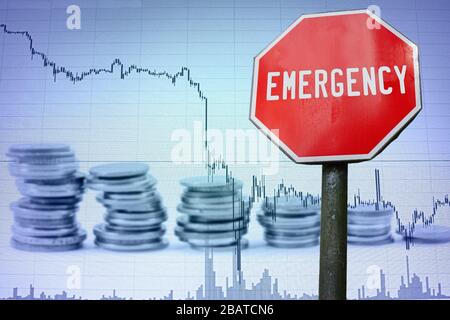 Emergency sign on economy background - graph and coins. Financial crash in world economy because of coronavirus. Global economic crisis, recession. Stock Photo