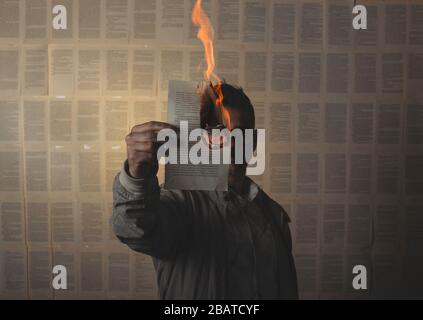 man holding a burning book sheet and looking through it. Conceptual image. Stock Photo